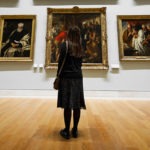 Visitor viewing paintings in an art museum